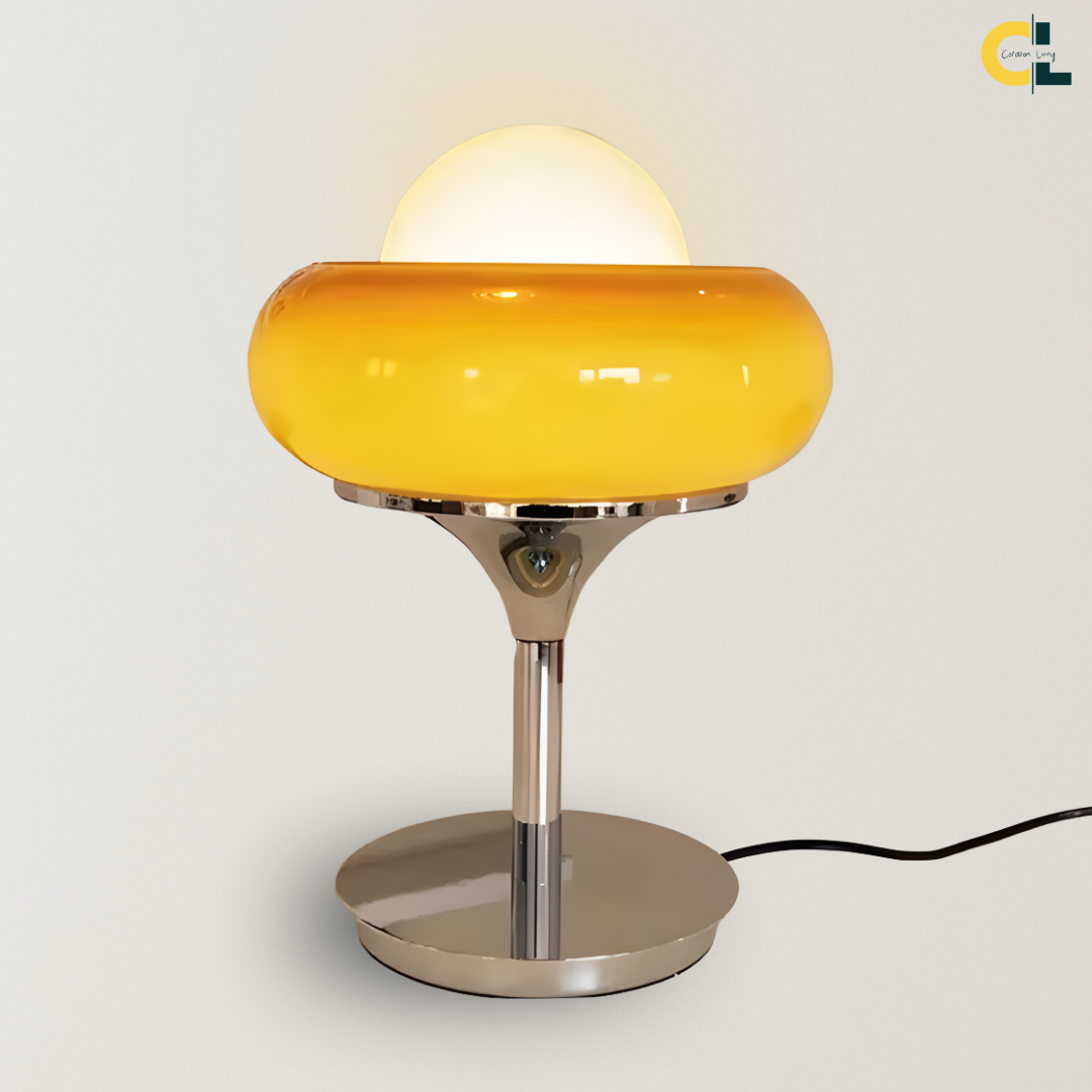Adeline Table Lamp with a glossy yellow hand-crafted glass shade, polished chrome base, and warm glowing dome detail, designed as a Bauhaus-inspired accent lamp for bedside tables, desks, and styled surfaces.