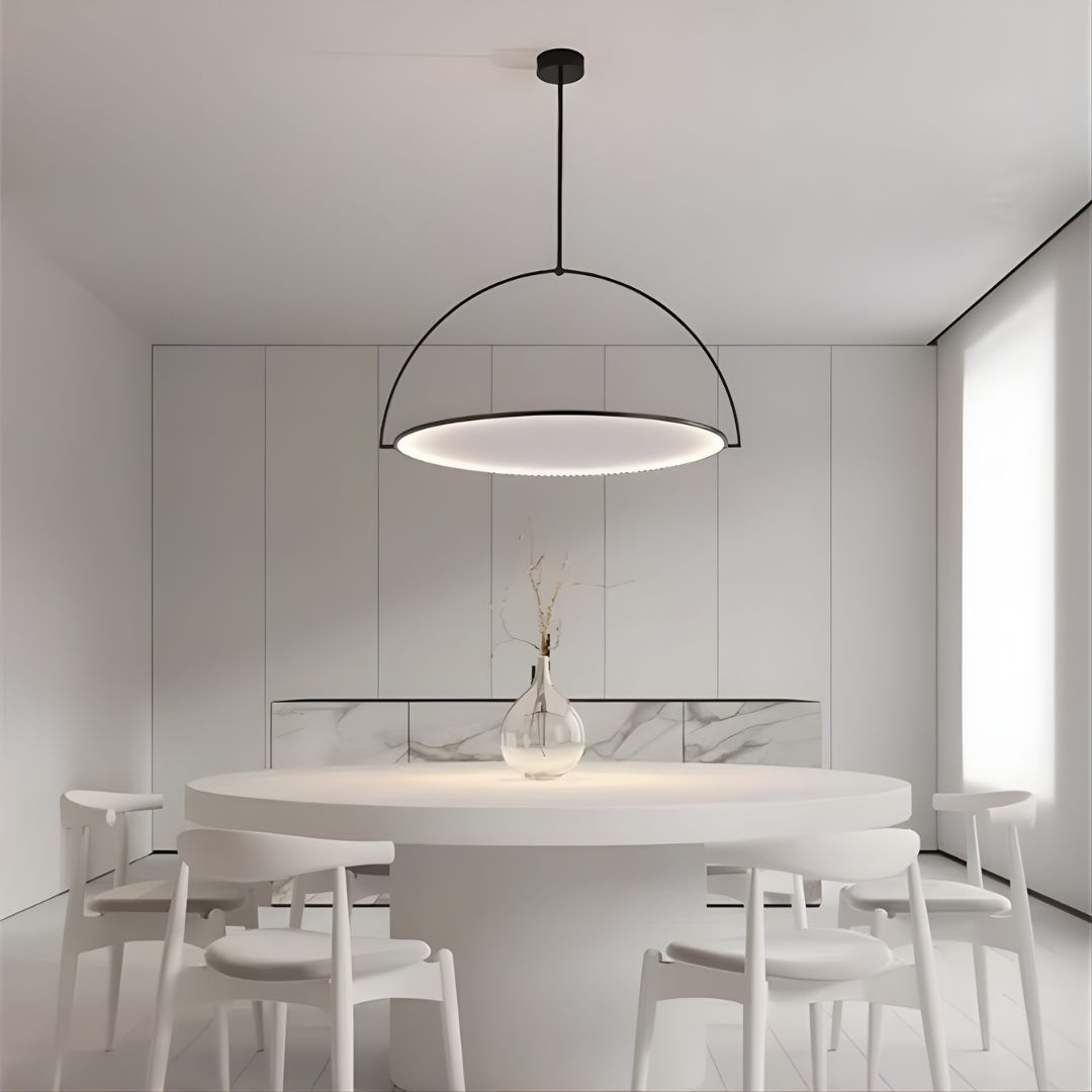 Lancelott UFO LED pendant light with a black arched frame, slim disc-shaped diffuser, and soft ambient glow above a modern white dining table.