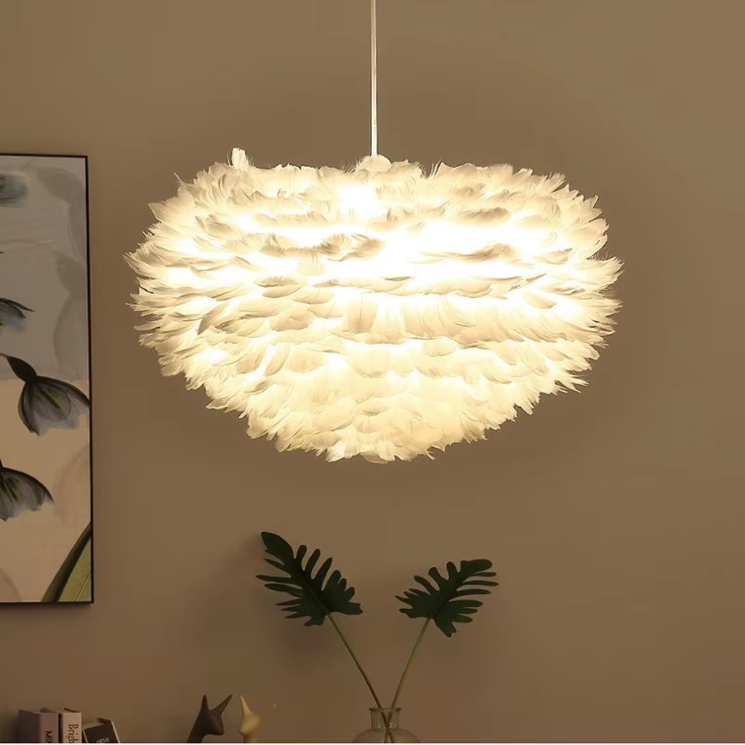 Orfeia Feather LED pendant lamp with layered white feathers and a soft warm glow, creating a cloud-like statement light for bedrooms, living rooms, or dining spaces.