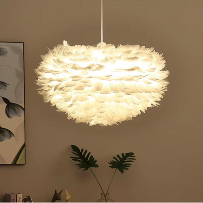 Orfeia Feather LED pendant lamp with layered white feathers and a soft warm glow, creating a cloud-like statement light for bedrooms, living rooms, or dining spaces.