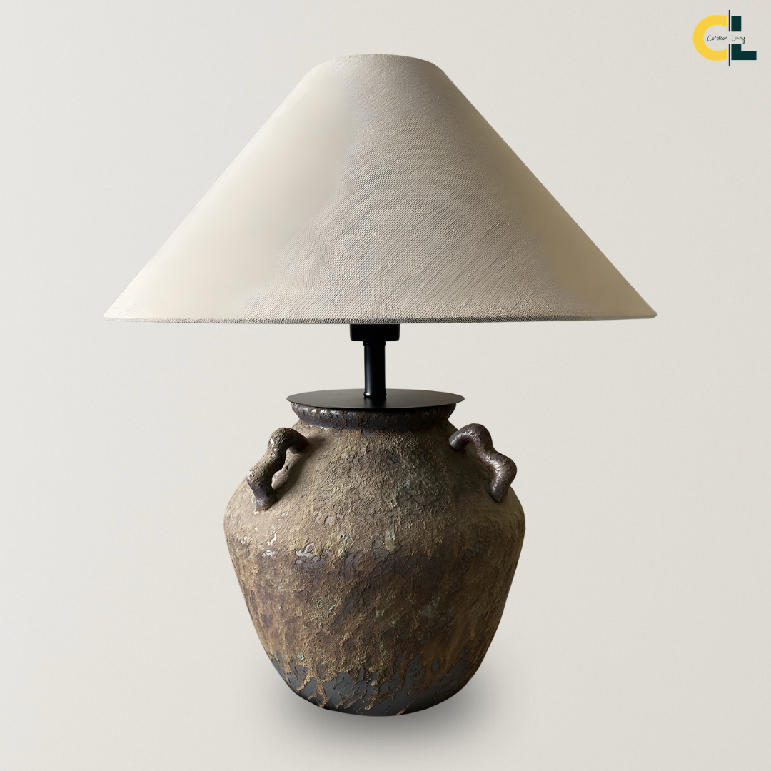 Susanna retro ceramic table lamp with a textured antique-style base, side handles, black metal detail, and warm fabric shade, designed for cozy bedrooms, living rooms, reading corners, and console styling.