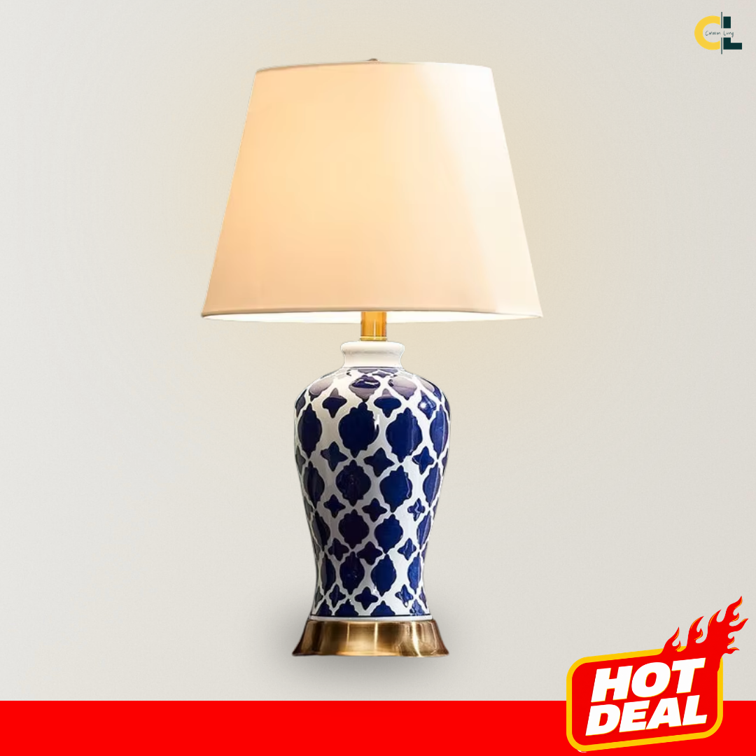Vivienne retro ceramic table lamp with a blue and white patterned base, brass-finished metal detail, and soft fabric shade, designed for warm ambient lighting on bedside tables, consoles, shelves, and home offices.